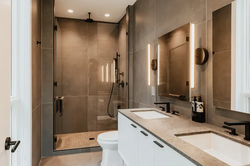 Modern walk-in shower with large-format tile and a frameless glass door